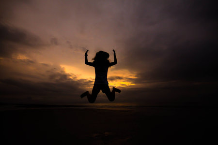 Happy jump sport young woman running on the beach at sunrise, asianの写真素材