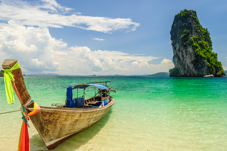 Thai Long Tail Boat Floating Nearby Island With Big Rock Behindの写真素材