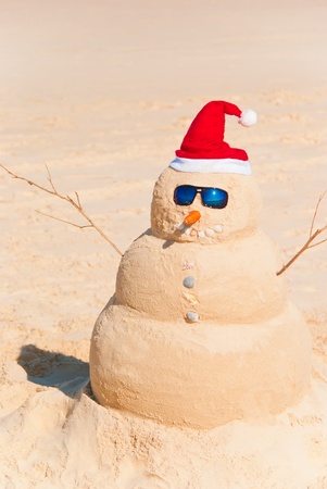 Sandman with santa hat, carrot nose and sun glasses on the beach. Global Warming Conceptの写真素材
