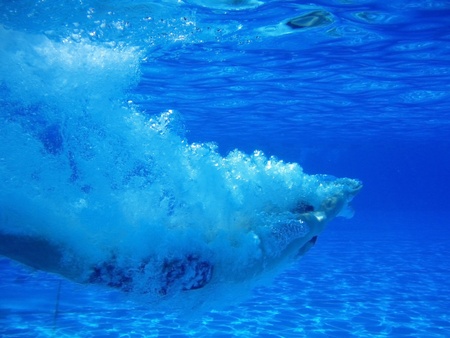 Underwater shot of a young man who dives head first into the pool