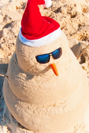 Birds Eye View On Snowman With sunnglasses and carrot nose on beachの写真素材