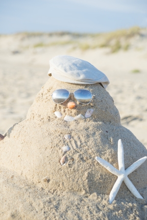 Snowman On Beach with shells as mouth and sun glassesの写真素材