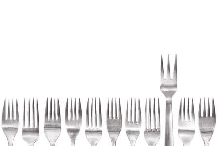 fork with three spikes standing out of the crowd of different shaped normal cutleryの写真素材