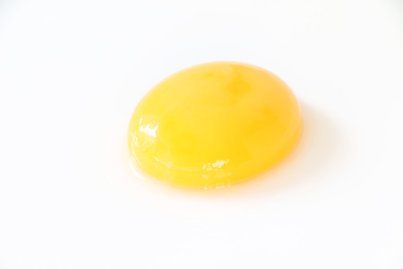 Single egg yolk on white isolated backgroundの写真素材
