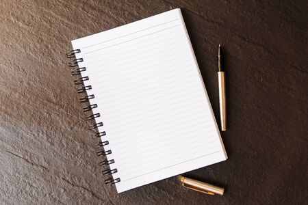 Note pad and pen on on dark grey background. Business conceptの写真素材