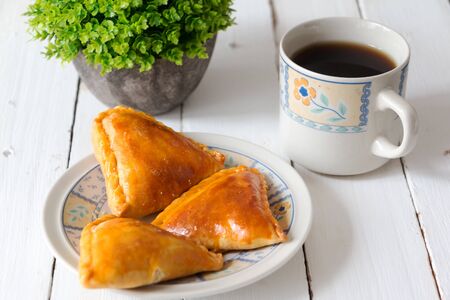 Chinese traditional flakes cookies served with coffee on white wooden tableの写真素材