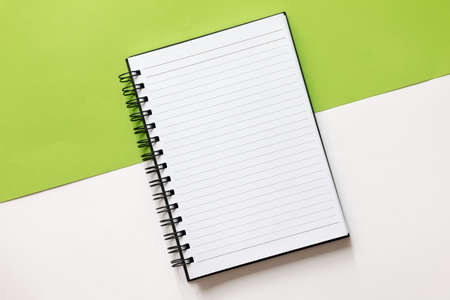 Flat lay of open notebook on split color green and white background with open space. Business conceptの写真素材