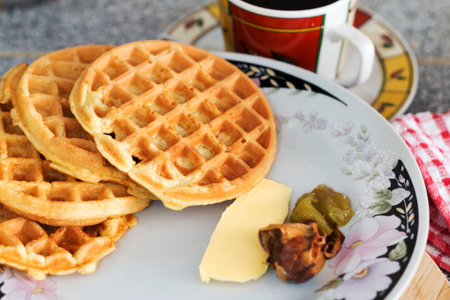 Close-up shot of mini round Waffles with butter, peanut, butter and Kaya jam served with coffeeの写真素材