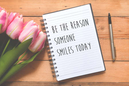 Fat lay of Tulip flowers and  Notebook with Quotes - Be the reason someone smiles todayの写真素材