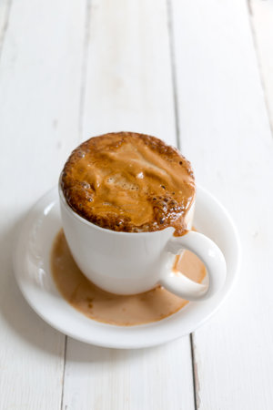 Hot Latte in white cup and saucer on white wooden table background with copy spaceの写真素材
