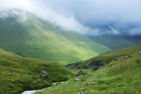 Mountains landscape, foggy valley. Summer green hills.