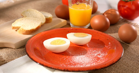 Eggs cut in half on a plate. breakfast on table. Boiled chicken eggs with bread and tomatoes. fresh...