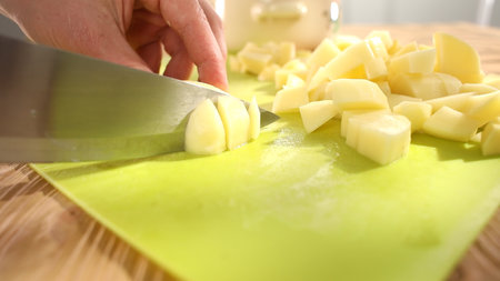 preparing fresh vegetables. cutting potatoes on a cutting board. healthly food. close up.の写真素材