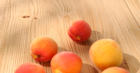 Apricots on a wooden table. Fresh fruits on a sunny day. Vegetarian food. Summer harvest. High quality photo.の写真素材