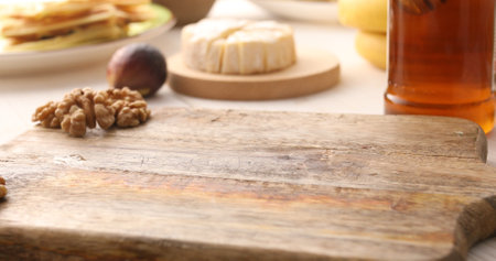 Empty space on a cutting board surrounded by nuts, cheese and honey. High quality photoの写真素材