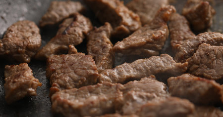 Sliced pieces of meat are fried in a frying pan. Roasting beef in a pan. Cooking in the kitchen. Food preparation. Close-up shot.の写真素材