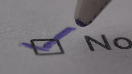 Pen checks the No box on a form. Extremely Close-up, shallow dof.