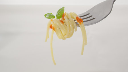 Twirled Spaghetti with Basil and Sauce on a Fork. Close-up, shallow dof.の写真素材