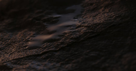 Trickling Water on Rough Stone Surface. Close-up, shallow dof.