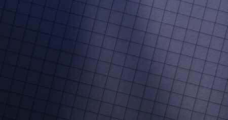 Close-up of a notebooks grid paper with soft light and shadow creating a dynamic effect. The grid pattern and lighting contrast make it suitable for abstract designs or backgrounds.の写真素材