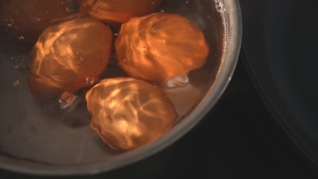 Top view of brown eggs boiling in kitchen potの写真素材