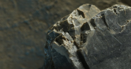 Close-up of layered slate rock with cracked lines and subtle blue shadowsの写真素材