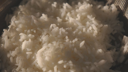 Cooked white rice in metal pot on wooden surfaceの写真素材