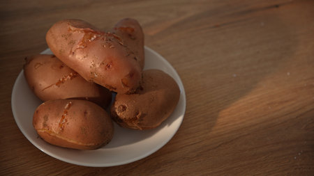 Close-up of boiled unpeeled potatoes stacked on plateの写真素材