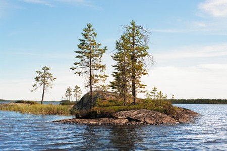 Small rocky island on lake on sundayの写真素材
