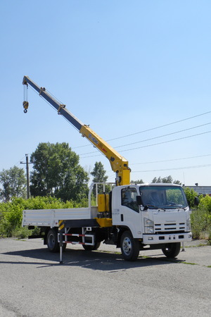 A White Isuzu flatbed truck with yellow crane arm is in the parking lot - Russia, Moscow, 30 August 2016のeditorial素材
