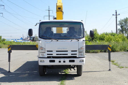 A White Isuzu flatbed truck with yellow crane arm is in the parking lot - Russia, Moscow, 30 August 2016のeditorial素材