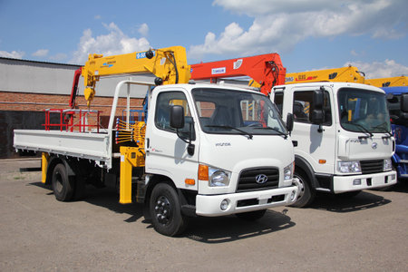 White Hyundai flatbed trucks with yellow, red crane arm is in the parking lot - Russia, Moscow, 30 August 2016のeditorial素材