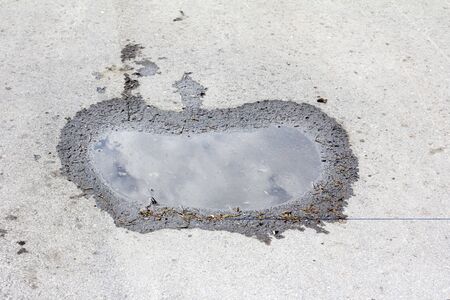 apple-shaped puddle on the pavementの写真素材