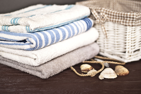 Bath towels of different colors on brown wooden deskの写真素材