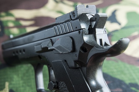 Firearm Pistol Clip And Hand Gun Ammunition on military camouflage background