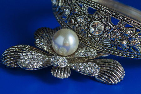 Pearl brooch isolated on a blue backgroundの写真素材