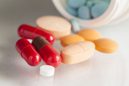 tablets and capsules in the lid on a white backgroundの写真素材