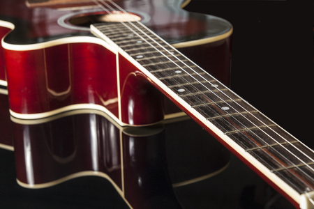 acoustic guitar in red on a black backgroundの写真素材