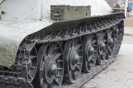 view of the front part of the green caterpillar of the tank standing on the ground with the wheels close-upの写真素材