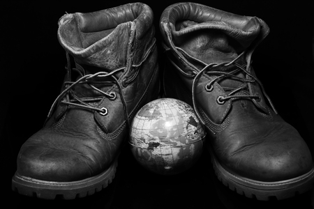 Boots, and a small globe Represents the journey that takes place just two human feet.の写真素材
