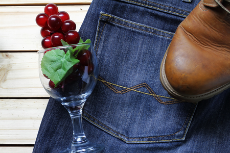 grapes on a jeans and glass and boots .wood backgroundの写真素材