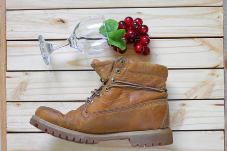 grape and glass and boots on wood back ground.の写真素材