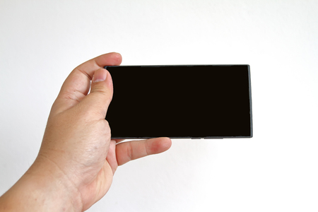 Hand holding smart phone isolated on white backgroundの写真素材