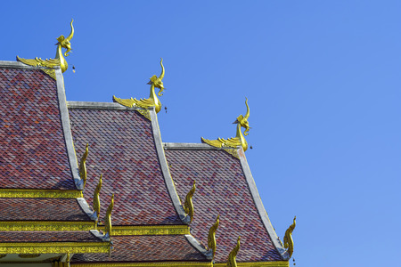 The roof of Thai temples adorned with statues of legendary animals adorned with gold.