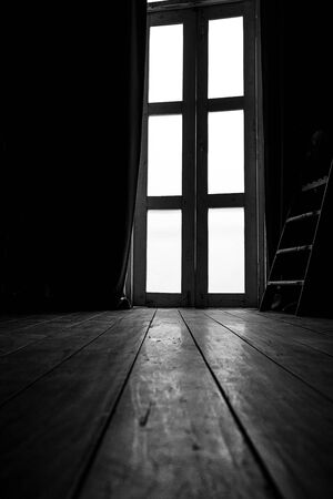 Curtains and light from glass doors, old wooden floors, black and white images, but only yellow tonesの写真素材