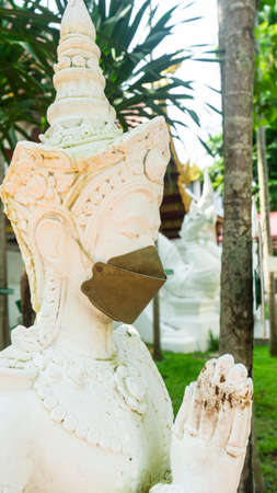 Statues of angels wearing masks to prevent covids from touristsの写真素材