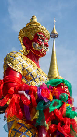 A giant red-colored statue guarding the temple.の写真素材