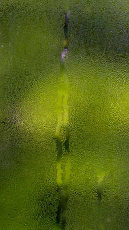 Water vapor on the glass is caused by the pouring rain. The background is green from the trees.の写真素材