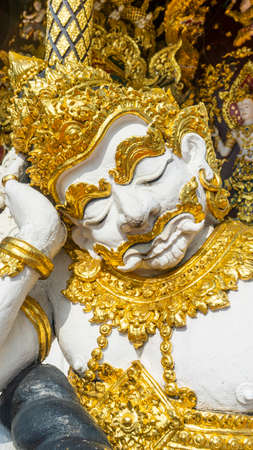 A giant statue sitting in front of the templeの写真素材