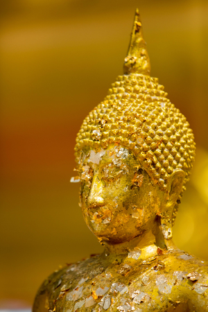 Selective focus Buddha face ,gold plates on buddha,The Buddha statue to gild with gold leafの写真素材